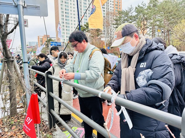 경기도교육청 인근 담장에 ‘경기도교육감에게 바란다’ 띠지를 묶는 전교조 조합원들.